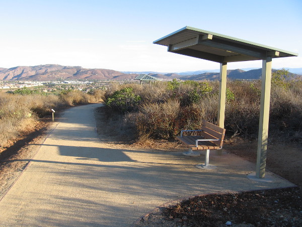 One of the benches and shelters along the Trail For All People. Views to the north include mountains and nearby 4S Ranch.