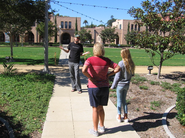 Two people on the North Promenade in the middle of the Arts District at Liberty Station learn how to take great photos from a personal instructor.
