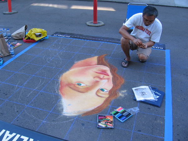 This chalk artist uses a grid to form his emerging creation.