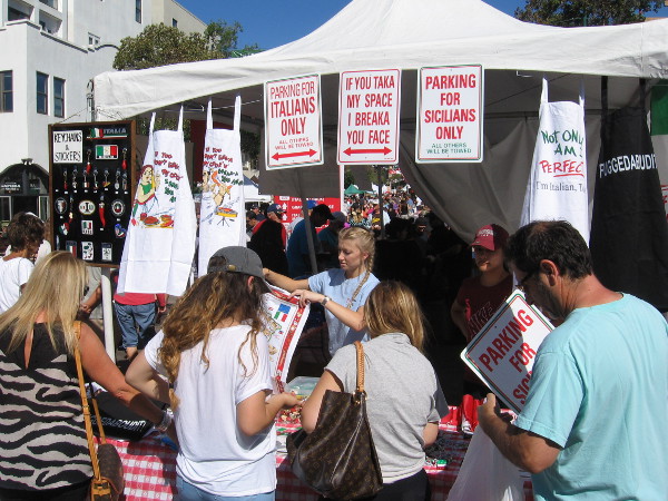 A vendor at Festa sells funny signs and aprons to Italy lovers.
