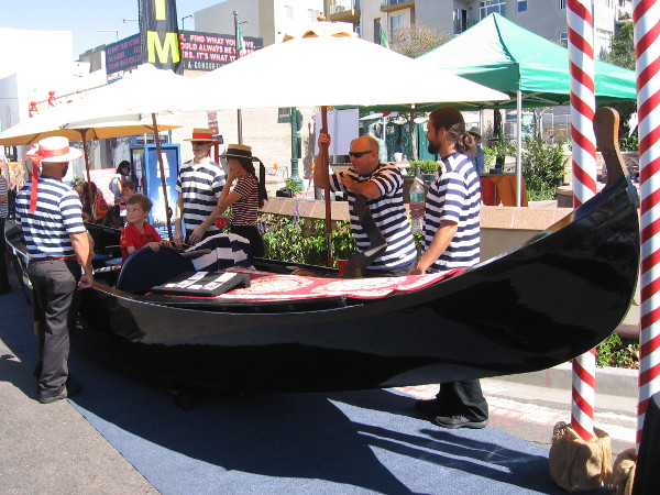 A kid and gondoliers at Festa. Anyone can ride elegant gondolas in San Diego at the Coronado Cays.