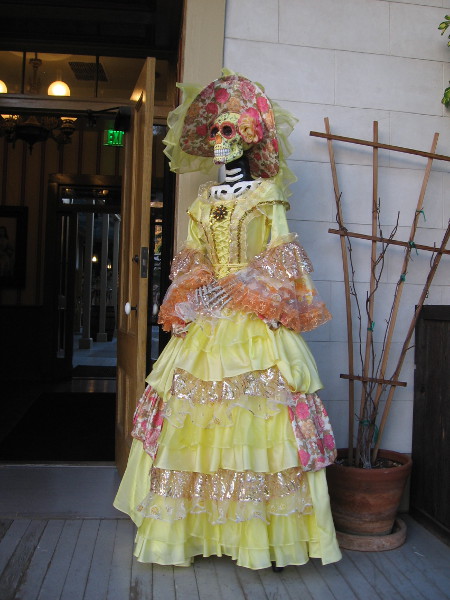 In celebration of Día de los Muertos, or Day of the Dead, two lady skeletons wearing frilly dresses greet visitors to the Cosmopolitan Hotel. Here's one.