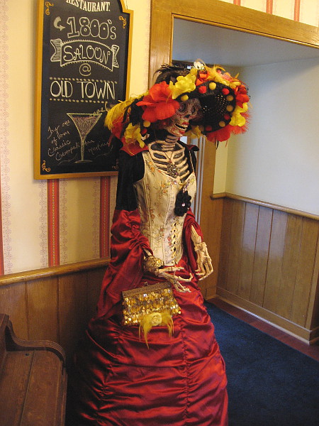 Inside the Cosmopolitan Hotel's saloon, more extremely elegant but skeletal customers are observed.