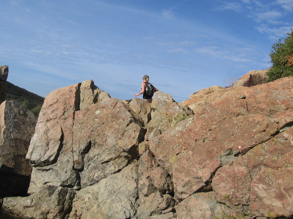 A hiker up above seems to walk in the sky.