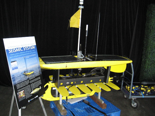 The Autonomously Deployed Deep-Ocean Seismic System's Wave Glider is powered by solar and wave energy. It links with satellites and ocean bottom seismometers to help predict earthquakes and tsunamis.