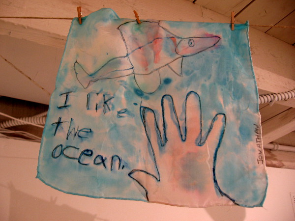 Artwork produced by thoughtful, creative kids hang from the ceiling. I like the ocean!