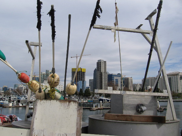 Floats with spear-like poles rise into the sky above downtown San Diego skyscrapers.