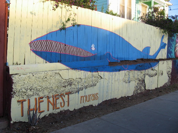 The Nest Murals include a big blue whale on a yellow fence in Barrio Logan, not far from downtown San Diego.