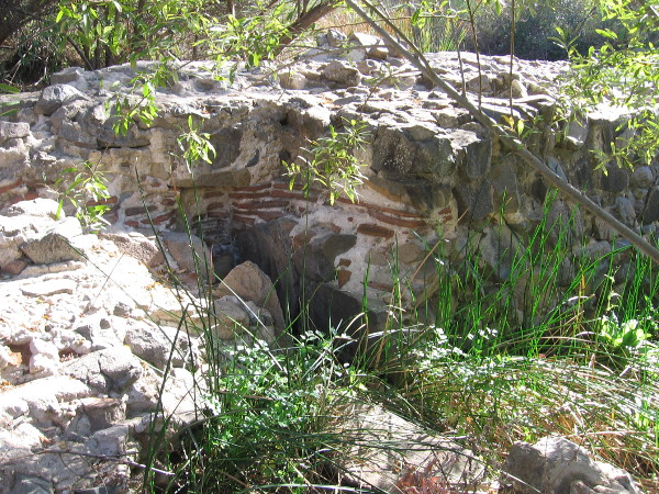 A slot in the dam wall where a water wheel was located. The river water, after driving the wheel, flowed along an aqueduct south to the mission, where it was used to grow crops.