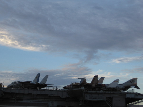 Jet aircraft high up on the flight deck of the USS Midway Museum in the late afternoon.