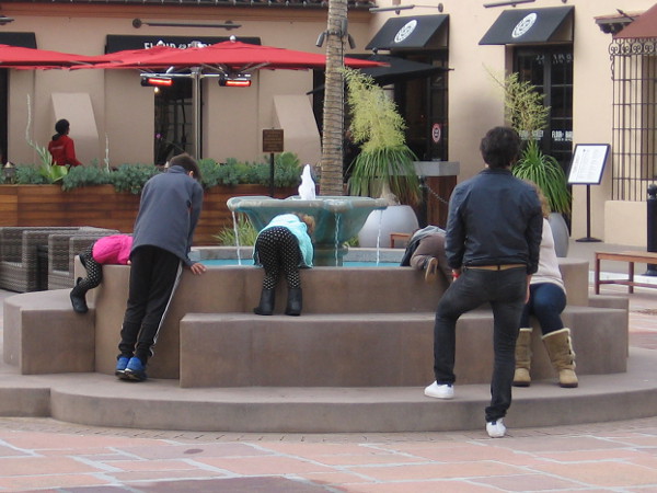 Youth peers into a fountain hopefully. What can one see? Dreams filled with light?