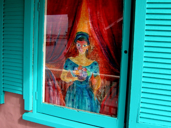A lady holding a colorful bouquet in the window of Seaport Deli and Salad Bar.