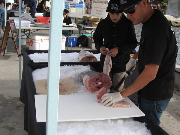 Some guys cut up fish. Customers can have their purchase filleted on the pier.