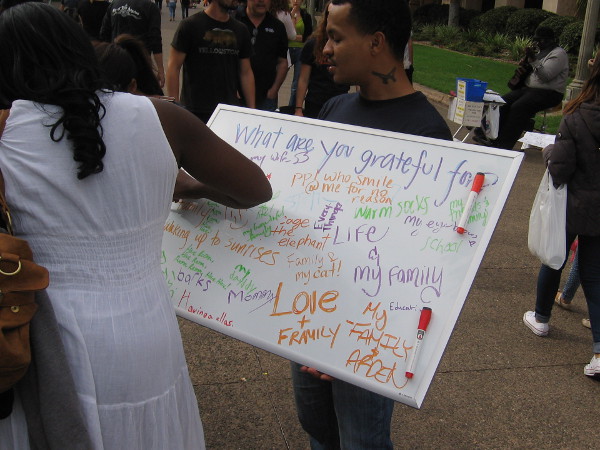 A random person walking along happily writes down a few reasons why they are thankful.