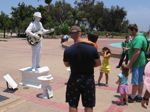 Families thrill to statue-like street musician in Balboa Park.
