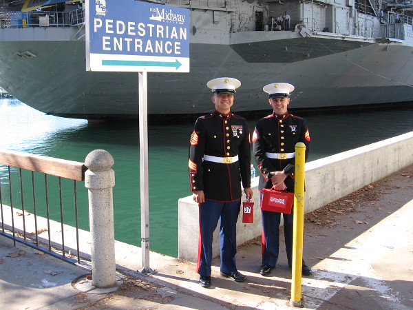 Marines stand at pedestrian entrance to Navy Pier, welcoming people to the Toys For Tots event by the USS Midway Museum.