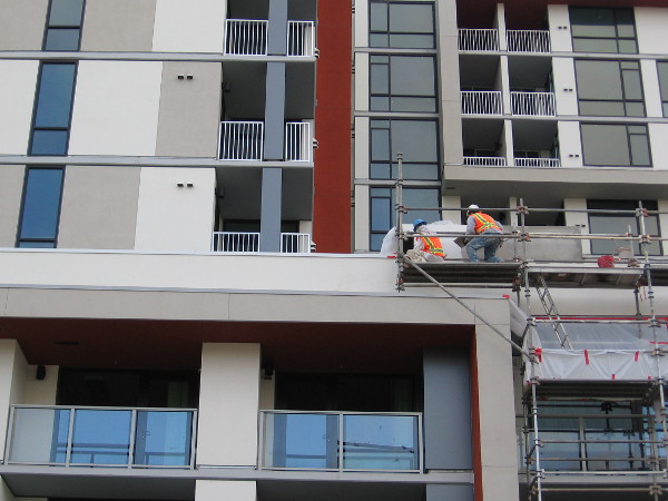 Construction workers put the finishing touches on a new downtown building.