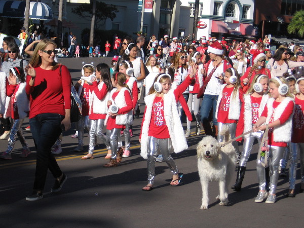 Here comes a Girl Scout Troop and a friendly dog.