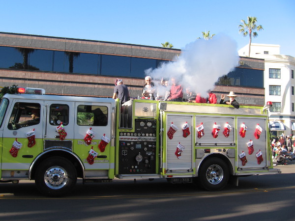 The La Jolla Sunrise Rotary Club was spraying Christmas snow onto the onlookers with their stocking covered fire truck!