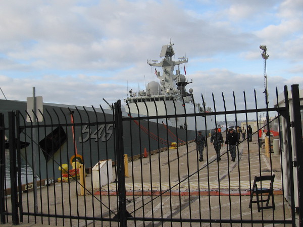 United States military personnel walk along the B Street Pier during a visit of the Chinese Navy to San Diego.