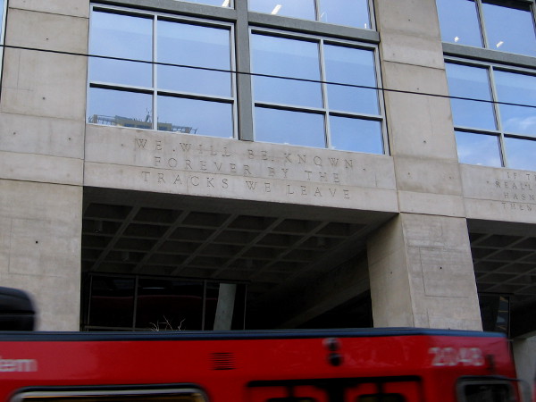 We will be known forever by the tracks we leave. A San Diego Trolley passes some wisdom written on the east side of the downtown public library.