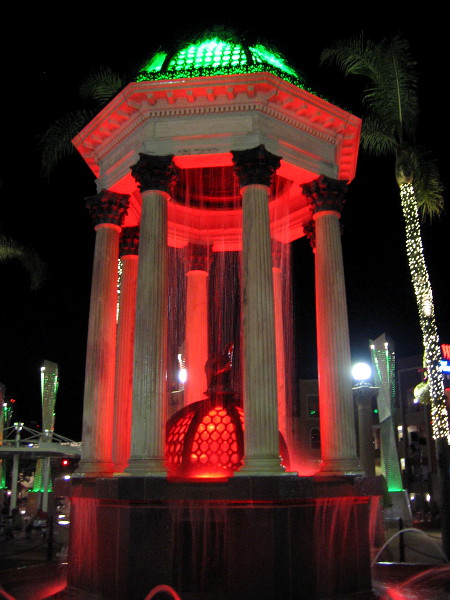 A closer photo of the handsome Broadway Fountain lit up at night with traditional Christmas colors.