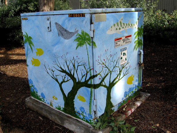 A transformer box with fish and whales swimming among trees and flowers!