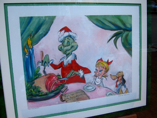The Grinch is behaving unexpectedly unGrinchlike in this fun artwork inside the front window of The Chuck Jones Gallery.