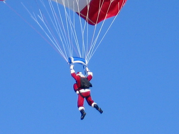 Old Saint Nick nimbly descends from the blue sky in order to greet the nice boys and girls of San Diego. Beats using a sooty chimney.