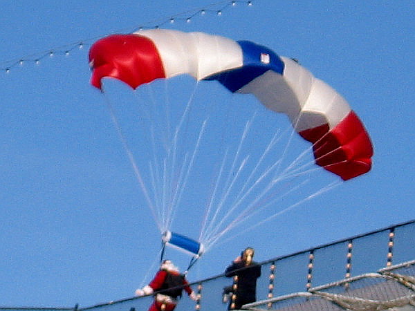 Santa doesn’t need a tailhook when landing atop a huge aircraft carrier. Just a sturdy parachute!