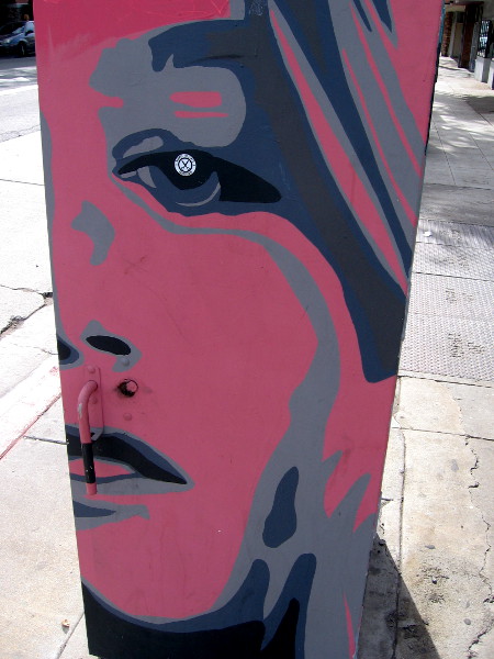 A third red face looks down the North Park sidewalk.