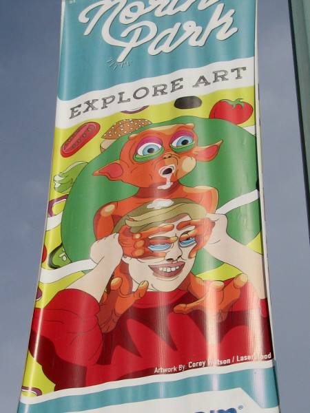 Street lamp banners along 30th Street in North Park feature imaginative faces. Explore Art.
