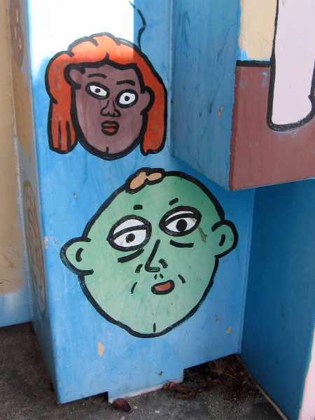 Funny graffiti faces on an electrical box.