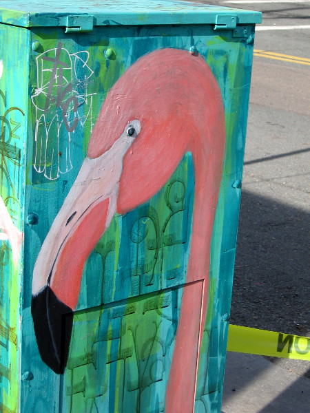 The face of a pink flamingo painted on a utility box!
