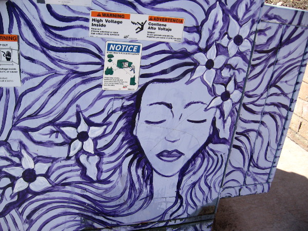 A lady with flowers in her long flowing purple hair.