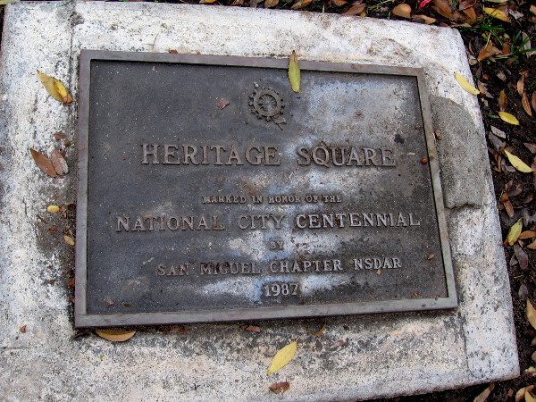 A plaque that reads Heritage Square - Marked in honor of the National City Centennial by San Miguel Chapter NSDAR, 1987.