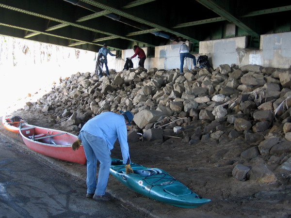 Picking up garbage and readying kayaks underneath the West Mission Bay Bridge.