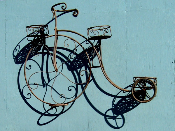 A cool decorative bicycle suspended from a wall. I spotted this at the Reusable Finds resale and repurpose store , near their entrance.