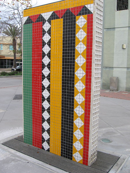 The beautiful patterns on this wall-like artwork are composed of many brightly colored tiles.