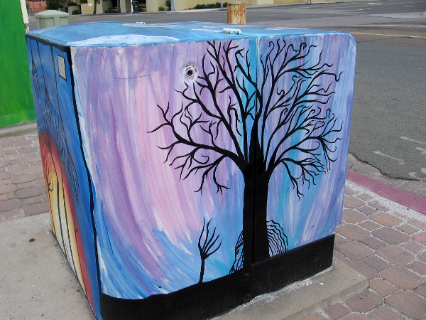 Barren trees in a purple-blue sky.