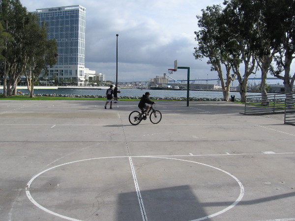 Two basketball players and a bicyclist. It's a fairly quiet day at Embarcadero Marina Park South.