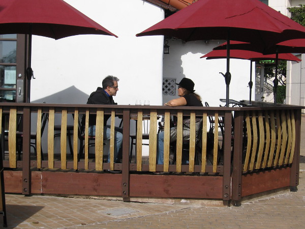 A couple enjoys outdoor conversation at Seaport Village's San Pasqual Wine Tasting Room.