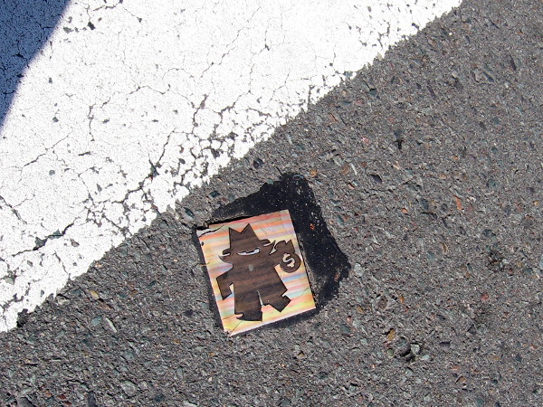 Crossing an intersection in the Gaslamp, I spotted an odd thing at ground level. This tile showing a burglar has been cemented to the asphalt in the middle of the street!