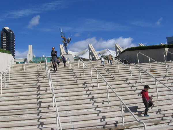People descend the San Diego Convention Center steps that lead to the Flame of Friendship sculpture.
