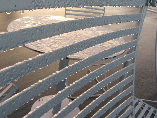 Water droplets cling to the metal seats and tables at the end of the Broadway Pier.