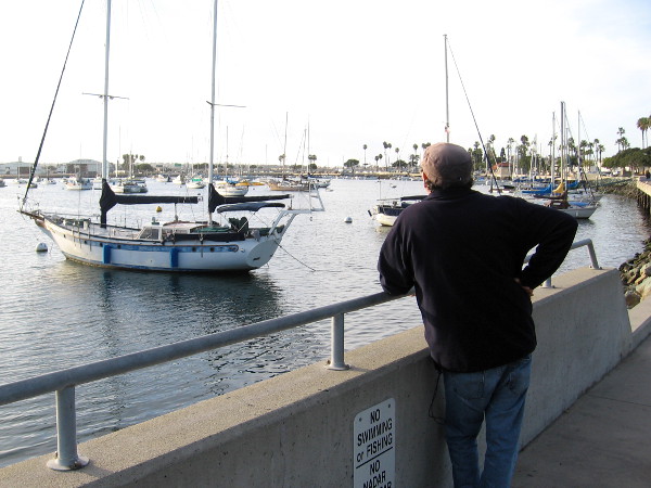 Someone stands by the water one late afternoon gazing at moored boats in the Crescent area of San Diego Bay.