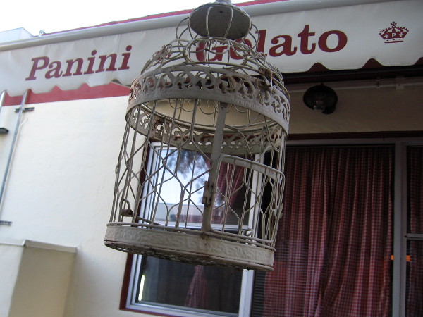 A fancy bird cage dangles beside Pappalecco, a cool Little Italy cafe.