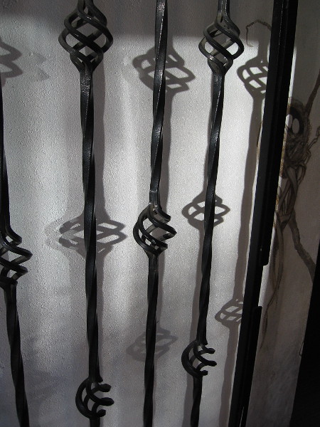 Interesting twisty iron gate and shadows.