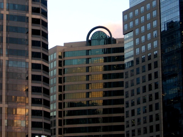 Sunset flames becomes glowing embers in the dark windows of several downtown skyscrapers.