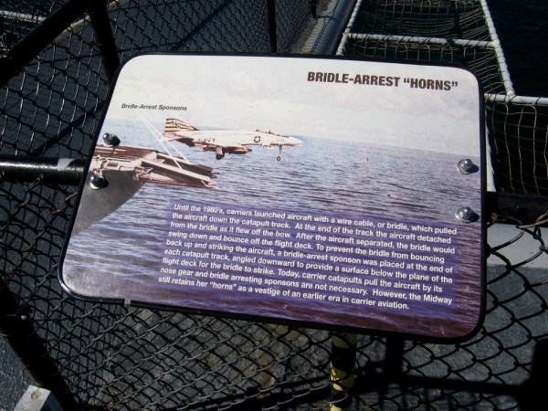 Sign at bow of USS Midway aircraft carrier explains the function of bridle-arrest horns. They were used until the 1980's. They are a vestige of an earlier era in carrier aviation.